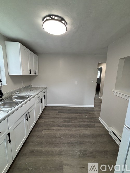 A kitchen with white cabinets and a marble countertop.