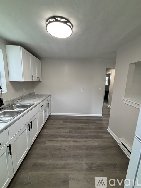 A kitchen with white cabinets and a marble countertop.