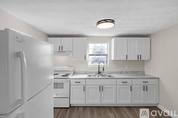 A kitchen with white appliances and cabinets.