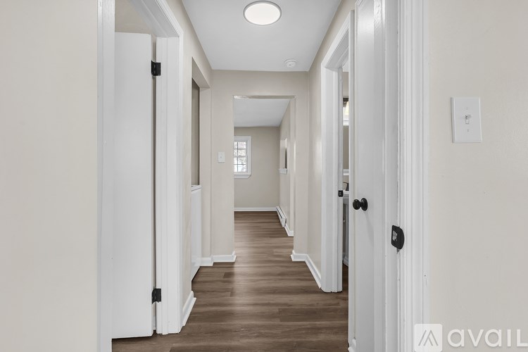 A long hallway with doors on both sides and a light on the ceiling.