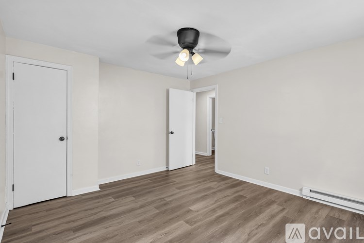 A room with a ceiling fan and wooden flooring.