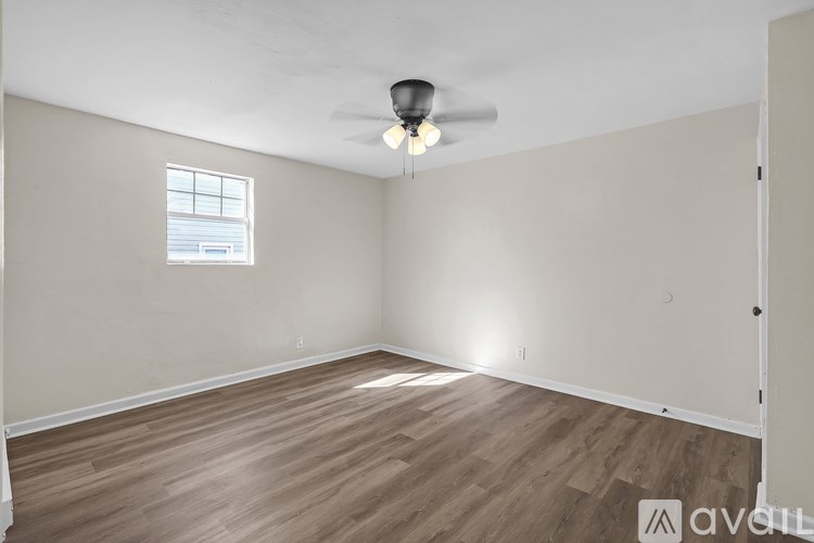 A room with wooden flooring and a ceiling fan.