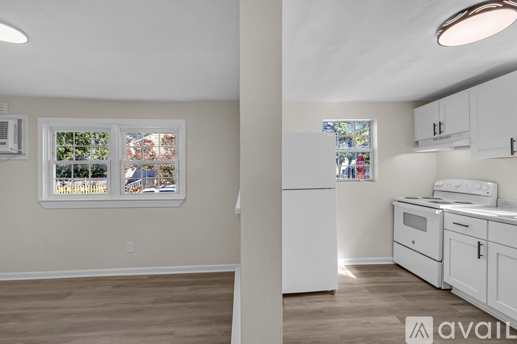 A kitchen with white appliances and cabinets is available for rent.