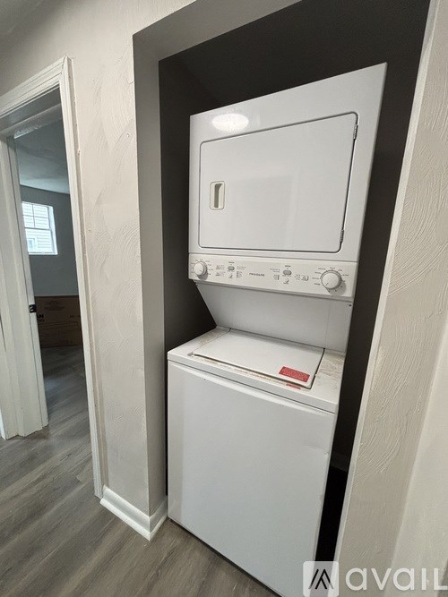 A kitchen with white appliances and cabinets is available for rent.