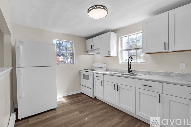 A kitchen with white appliances and cabinets.