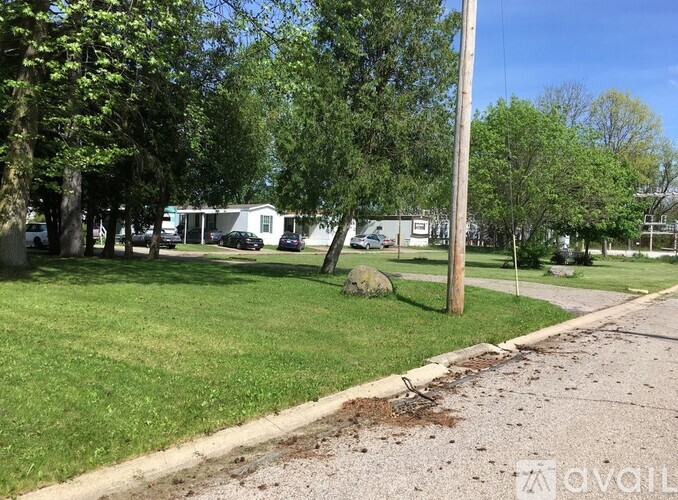A grassy area with a sidewalk and a utility pole.