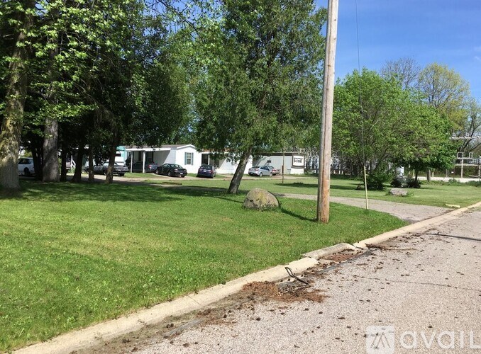 A grassy area with a sidewalk and a utility pole.
