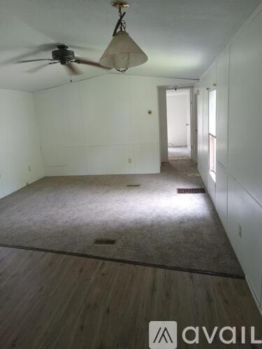A room with a ceiling fan and a carpeted floor.