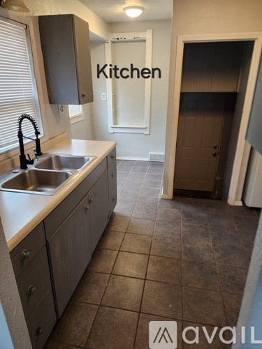 A kitchen with a sink and a cabinet.