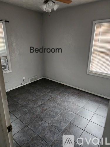 A room with tile flooring and a ceiling fan.