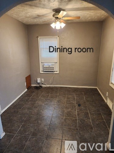 A dining room with tile flooring and a ceiling fan.