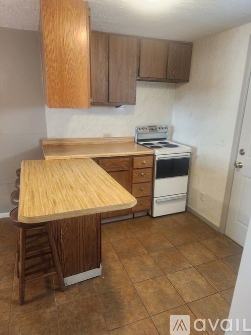 A kitchen with a wooden counter and a white stove.