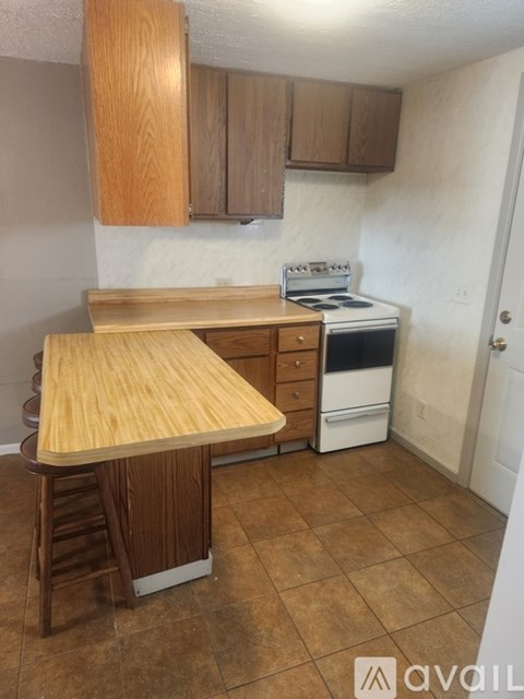 A kitchen with a wooden counter and a white stove.