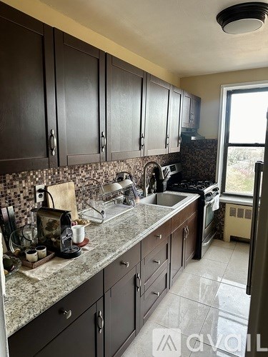 A kitchen with dark wood cabinets and granite countertops.