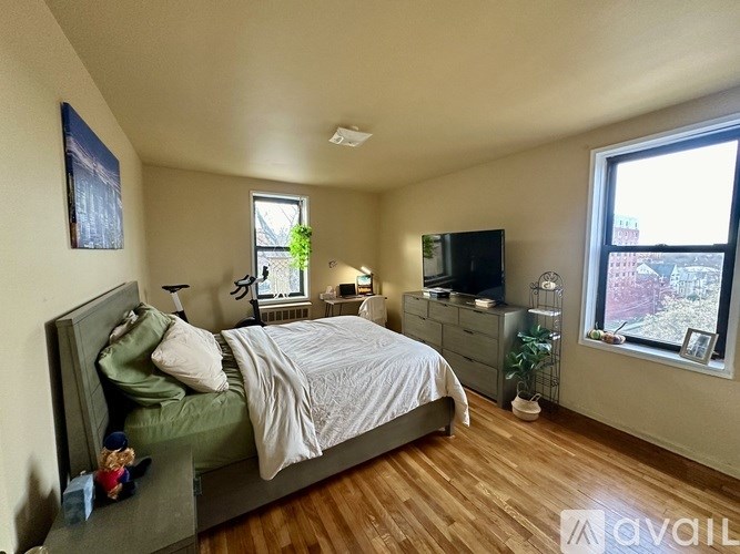 A bedroom with a bed, dresser, and window.
