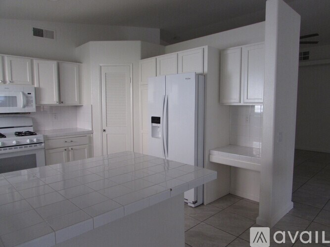 A kitchen with white appliances and cabinets.