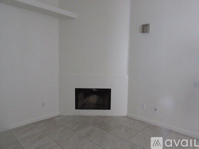 A room with a fireplace and tiled floor.