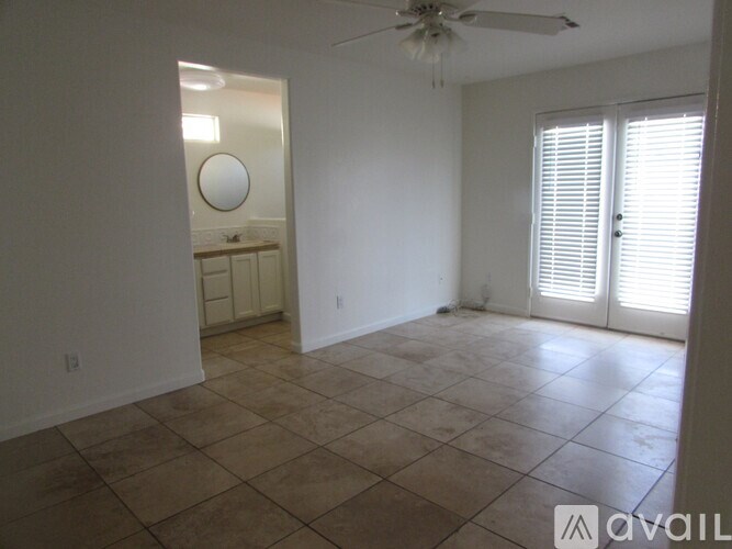 A room with a ceiling fan and tiled floor.
