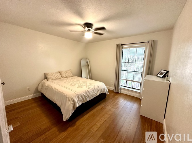 A bedroom with a bed, dresser, and window.