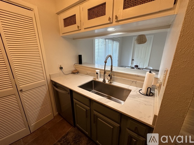 A kitchen with white cabinets and a sink.