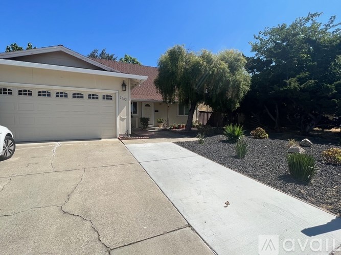 A house with a white garage door and a driveway leading to it.