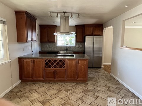 A kitchen with wooden cabinets and a granite countertop.