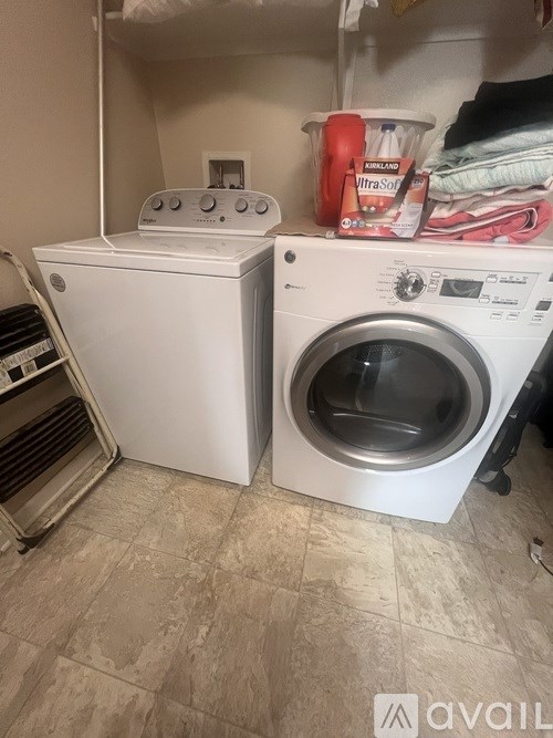 A white dryer and washer are in a small laundry room.