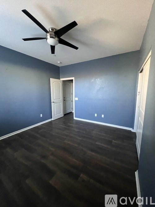 A room with a ceiling fan and a door.