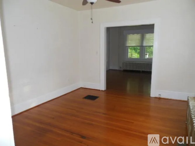 A room with wooden floors and a ceiling fan.