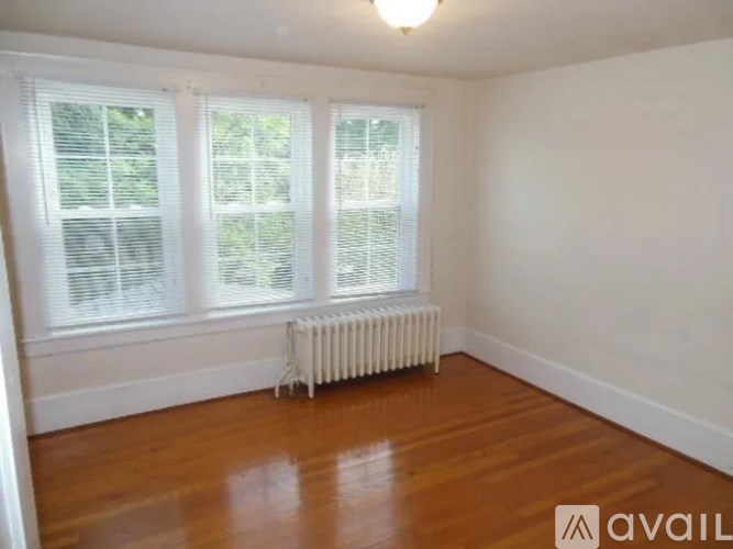 A room with wooden floors and a white radiator.