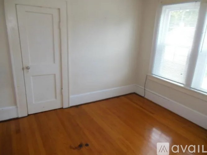 A room with a white door and a window with blinds.