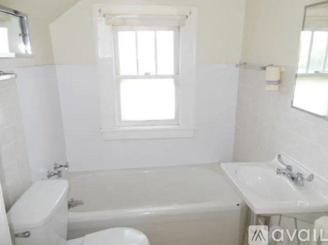 A white bathroom with a tub, toilet and sink.