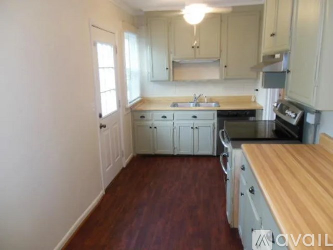 A kitchen with wooden floors and white walls.