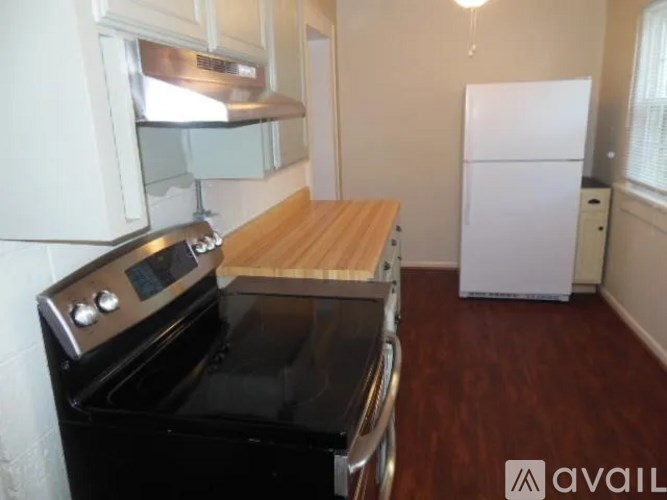 A kitchen with a black stove top oven and a white refrigerator.