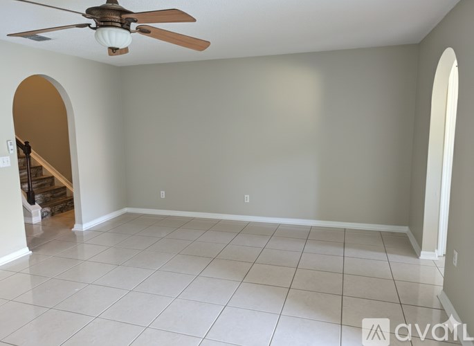 A room with a ceiling fan and tiled floor.