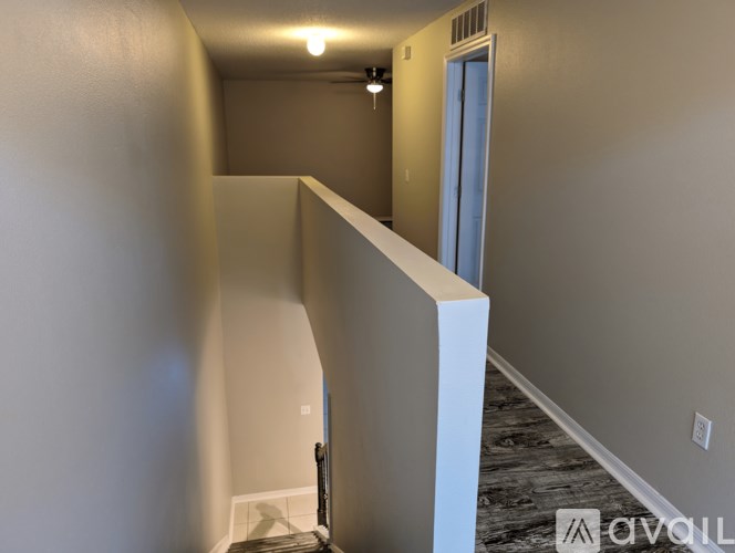 A hallway with a white door and a light on the wall.