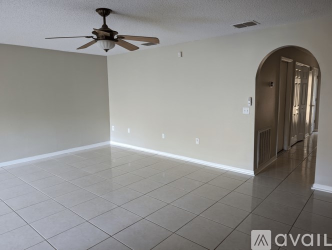 A room with a ceiling fan and tiled floor.