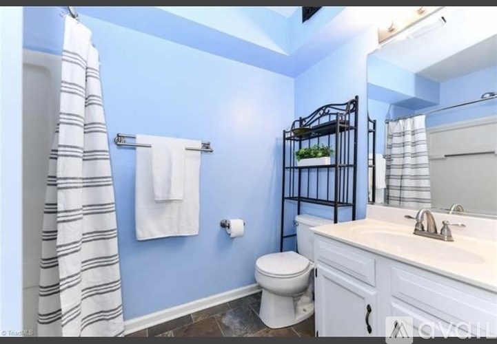 A bathroom with blue walls and a white toilet.
