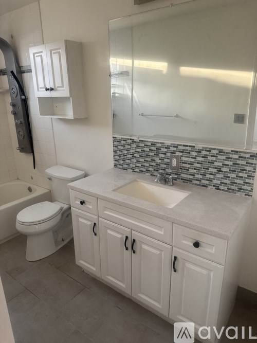 A bathroom with a toilet, sink, and a bathtub.