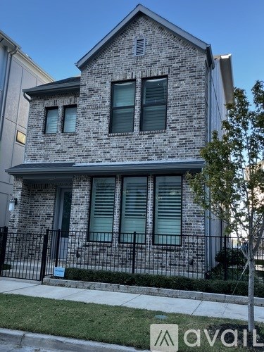 A two-story house with a black fence in front.