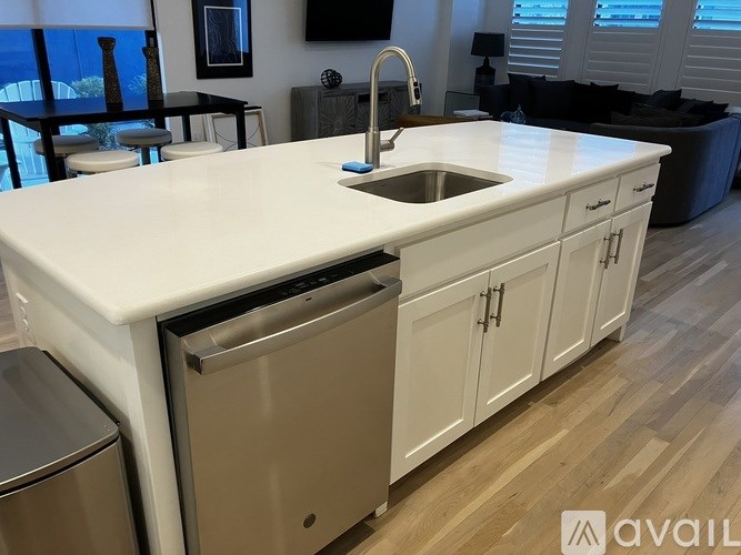 A kitchen with a white countertop and a stainless steel dishwasher.