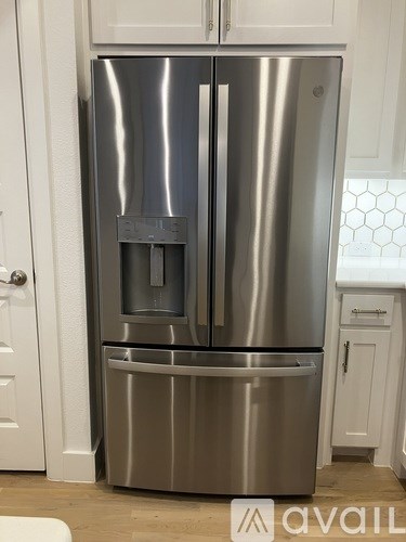 A stainless steel refrigerator with a water and ice dispenser in the middle.