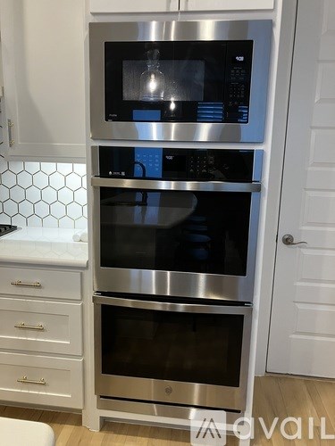 A kitchen with a stainless steel oven and microwave.