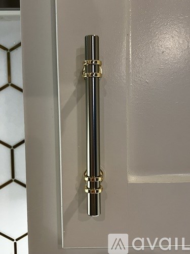 A door handle with a gold finish on a white door.