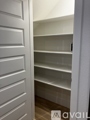 A white door with a shelf behind it.