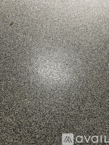 A grey textured surface with a logo in the bottom right corner.