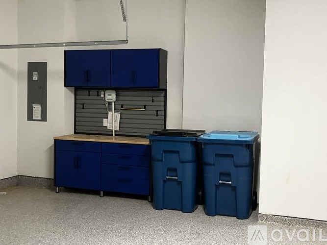 A room with a blue cabinet and two bins.