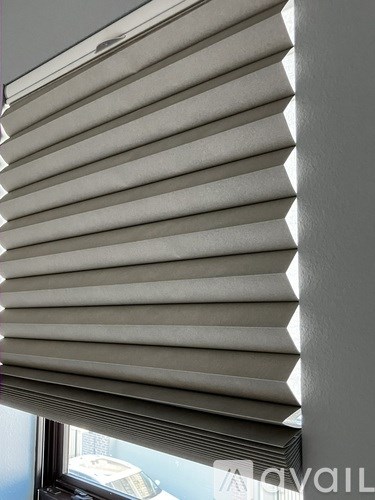 A close up of a window with white blinds.