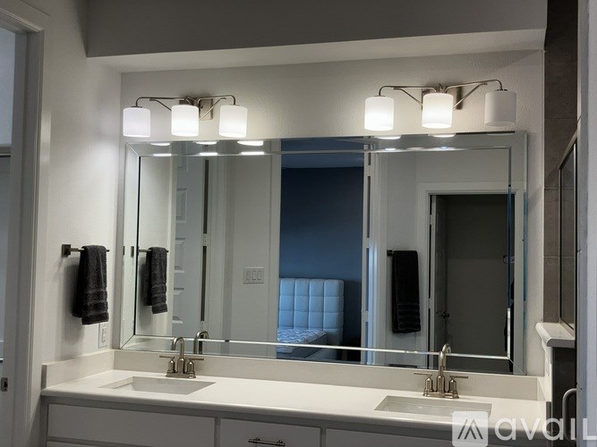 A bathroom with a white sink and a large mirror above it.
