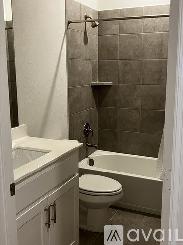 A bathroom with a toilet, sink, and bathtub.